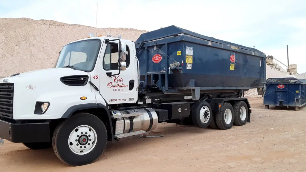 Side view of a roll off dumpster truck.